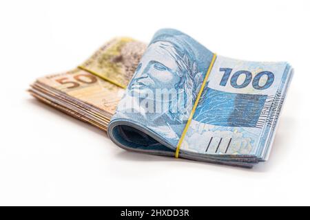 Viele Banknoten von 100 und 50 reais, brasilianisches Geld, tausend reais, Zahlung, Gehalt, Auf isoliertem weißem Hintergrund Stockfoto