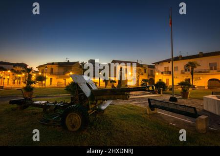 Ein italienisches Artilleriesstück bei Sonnenaufgang auf der Piazza Caduti in Guerra, ein Denkmal für den Tod des Krieges aus der Kleinstadt Carinaro, Italien. Stockfoto