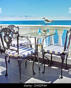 Urlaub am Ufer. Tische und Stühle auf dem Balkon eines Restaurants am Meer. Stockfoto