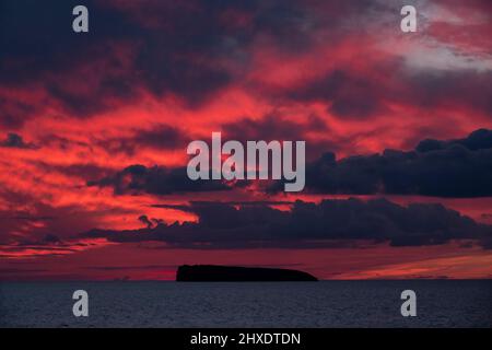 Maalaea, Maui, Hawaii, USA. 7. März 2022. Die Sonne untergeht hinter Molokini, ist ein halbmondförmiger, teilweise untergetaucht vulkanischer Krater, der eine kleine, unbewohnte Insel zwischen den Inseln Maui und KahoÊ»olawe innerhalb von Maui County bildet. Die Gegend ist ein beliebter Tauch- und Schnorchelplatz. (Bild: © K.C. Alfred/ZUMA-Pressdraht) Stockfoto