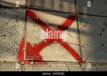 Gemaltes rotes Kreuz auf dem Bürgersteig, Thessaloniki, Griechenland. Stockfoto