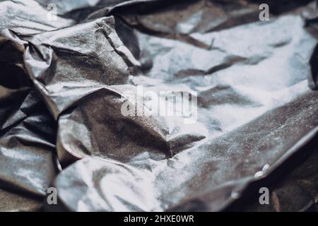 Abstrakt realen Papier Oberfläche Hintergrund. Aluminiumfolie Platinum Silver. Zerknittert zerknittert Falten biegen Quetschfalten Knick. Kristallklare, polygonale Texturwelle Stockfoto