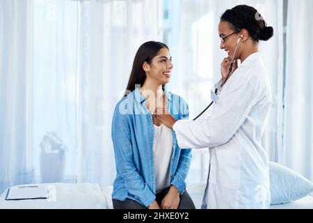 Starke Lungen, die Sie dort haben. Aufnahme einer jungen Ärztin, die ihre Patientin mit einem Stethoskop untersucht. Stockfoto