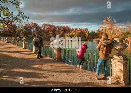 Frau, die ein Foto von einem Mädchen macht, das die Enten des Flusses Tejo im Parterre-Garten in Aranjuez, Madrid, Spanien, betrachtet. Stockfoto