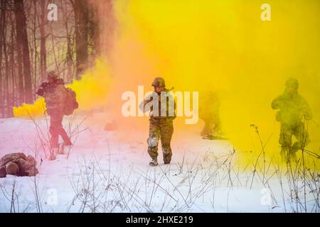 18. Februar 2022 - Camp James A. Garfield Joint Mil, Ohio, USA - Staff Sgt. Madison Bedor und ihre Truppenkollegen, alle 926. Studenten des Kurses „Security Forces Squadron Defenders“ und „Integrated Defence Leadership“, tauchen aus einem Rauchvorhang auf, während sie während einer Übung im Camp James A. Garfield Joint Military Training Center, 18. Februar 2022, eine gegnerische Truppenposition angreifen. Bevor und ihre Teammitglieder erholten während des Angriffs simulierte kritische Komponenten und Waffen. IDLC ist eine intensive, zweiwöchige, praxisorientierte Lernerfahrung, die Reserve Defenders dabei helfen soll, die Kampfbereitschaft zu erreichen und aufrechtzuerhalten Stockfoto