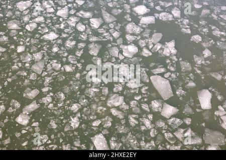 Gebrochene Frühlingseisschollen schweben auf der Flußantenne von oben von der Drohne aus Stockfoto