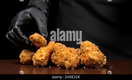 Cool schöne Frische saftige gekocht Chicken Wings in Panade. Buffalo Wings Spread auf Lebensmittel weiß Platte in der Tabelle. Sehr lecker und schön. Kochen mit Stockfoto