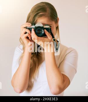 Diesen Moment in der Zeit einfrieren. Aufnahme einer unerkennbaren jungen Frau, die zu Hause mit ihrer Kamera ein Foto gemacht hat. Stockfoto