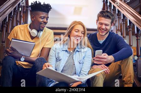 Die Aufgabe zu erfüllen und eine bessere Zukunft aufzubauen. Eine kurze Aufnahme einer Gruppe von Studenten, die auf dem Treppenhaus auf dem Campus zusammenarbeiten. Stockfoto