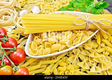 Pasta Muschelschalen und Spaghetti in Schüssel, Pipe Rigate, Tagliatelle, Fusilli, Penne, farfalle, conquilla, trenette, rotini, pappardelle, Tomaten, Knoblauch Stockfoto