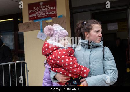 9. März 2022, Przemy?l, WojewÃ³dztwo Podkarpackie, Polen: Eine Mutter trägt ihr Baby, während sie aus der Grenzkontrolle herauskommt, nachdem sie aus dem Zug aus Lemberg aussteigen. Millionen von Ukrainern flohen aus ihrer Heimat, als die anhaltende Kriegskrise in der Ukraine anhält. Der Leiter der UN-Flüchtlingsbehörde (UNHCR) sagte, dass die Zahl der Flüchtlingsmigration 2 Millionen erreicht habe. (Bild: © Alex Chan Tsz Yuk/SOPA Images via ZUMA Press Wire) Stockfoto