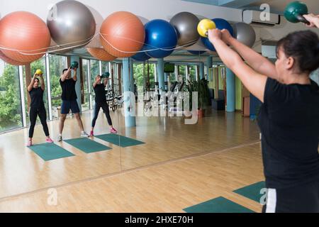 Fitness Gruppe von Menschen, die Powerlift-Übungen mit Kettlebells in einem Fitnessstudio Stockfoto