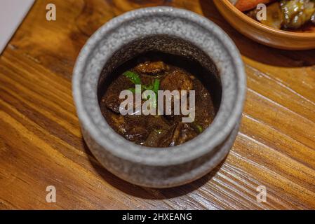 Geschmortes Rindfleisch Teriyaki in einem traditionellen Hotpot auf einem Tisch in einem Restaurant Stockfoto