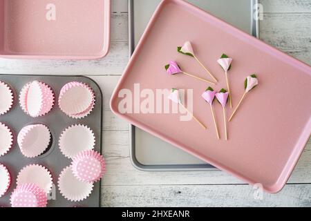 Plätzchenlaken und Tasse Muffin Pfanne mit Papiereinlagen Nahaufnahme auf hellem Holzhintergrund, flach legen Stockfoto