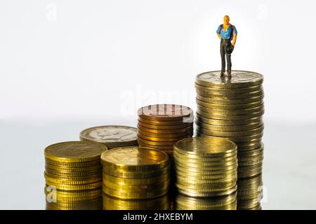 Miniatur Menschen Geschäftsmann auf Münze weißen Hintergrund stehen. Erfolgskonzept. Stockfoto