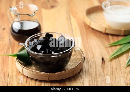 Gewürfeltes Schwarzgras-Gelee (Cincau Hitam), indonesisches Dessert aus Cincau Leaf, in der Regel mit Kokosmilch und Palmzucker-Sirup essen. Beliebt bei Tak Stockfoto