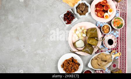 Ketupat Lebaran IED Menu Dish, Opor Ayam, Sambal Goreng ATI Kentang, Balado Telur, Datteln Fruit, Sambal und Tea. Draufsicht mit Kopierbereich für Banner Stockfoto