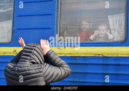 Eine Frau wird durch ein Kutschenfenster des Evakuierungszuges am Bahnhof in Kramatorsk gesehen, wie sie Kinder unterhält. Die Flüchtlingsflut, die vor dem Krieg nach dem russischen Einmarsch in die Ukraine fliehen musste, wird immer größer. Das Flüchtlingshilfswerk der Vereinten Nationen UNHCR berichtet, dass mehr als 2,5 Millionen Ukrainer das Land verlassen haben und weitere 1,85 Millionen Einwohner innerhalb der Ukraine vertrieben wurden. Kredit: SOPA Images Limited/Alamy Live Nachrichten Stockfoto