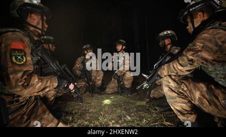 BAISE, CHINA - 10. MÄRZ 2022 - Soldaten der Spezialeinsatzkräfte nehmen an einem nächtlichen Kampftraining in der Stadt Baise, dem südchinesischen Guangxi Zhuang, Teil Stockfoto