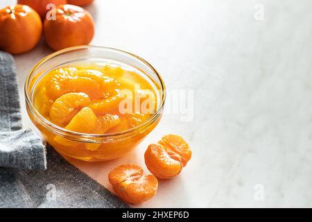 Mandarine aus der Dose. Eingelegte Mandarinenfrüchte in der Schüssel auf dem Küchentisch. Stockfoto