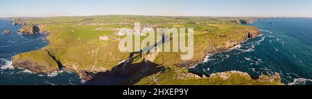 Luftdrohnenaufnahme von Tintagel, einem zerklüfteten und felsigen Küstenabschnitt mit Klippen und rauer See, Cornwall, Südwestengland Stockfoto