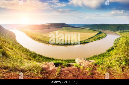 Sinuöser Fluss, der im Sonnenlicht durch den Canyon fließt. Dramatische und malerische Szene. Ort Ort Dnister. Ukraine, Europa. Beauty-Welt. Stockfoto