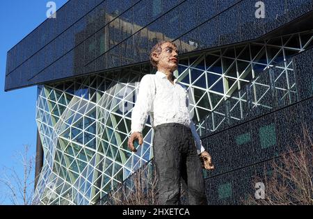 Berlin, Deutschland. 09. März 2022. Der Neubau des Axel Springer Verlages (Zimmerstraßenseite). Im Vordergrund die Skulptur Balanceakt des deutschen Bildhauers Stephan Balkenhol. Der Entwurf für das moderne Bürogebäude stammt vom renommierten niederländischen Architekten Rem Koolhaas (Office for Metropolitan Architecture), der sich bei einem früheren Planungswettbewerb über 17 Architekturbüros durchgesetzt hat. Quelle: Soeren Stache/dpa-Zentralbild/dpa/Alamy Live News Stockfoto