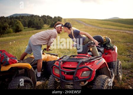 Liebevolles Paar, das abseits der Straße fährt und auf extremer Fahrt auf den Bergen genießt Stockfoto