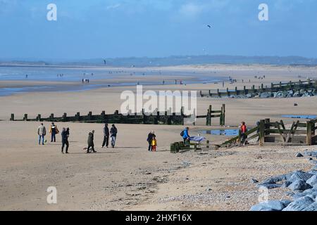 Camber, East Sussex, Großbritannien. 12 März 2022. UK Wetter: Einige erfahrene Kitesurfer trotzen den sehr windigen Bedingungen am Camber Sands in East Sussex. An einem windigen, aber sonnigen Morgen gehen viele Leute zum Strand. Foto-Kredit: Paul Lawrenson /Alamy Live Nachrichten Stockfoto