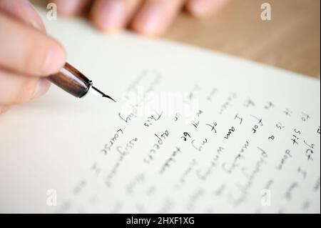 Schreiben eines Briefes an einen Freund. Hand hält einen Füllfederhalter. Stockfoto