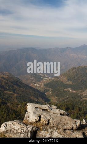 Die Spitze der schneebedeckten Himalaya-Bergketten ist im Hintergrund teilweise mit Felsen im Vordergrund sichtbar Stockfoto