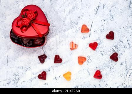 Herzförmige Bonbons mit einer Geschenkbox aus Metall zum Valentinstag oder Frauentag. Draufsicht. Stockfoto