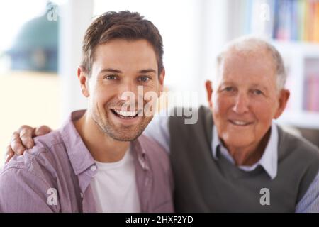 Er lehrte mich, wie man ein Mann ist. Porträt eines Vaters und eines Sohnes, die in ihrem Wohnzimmer sitzen. Stockfoto