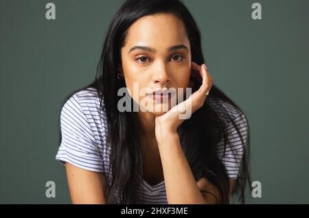 Manchmal ist der Kampf zu viel. Beschnittenes Porträt einer attraktiven jungen Frau, die im Studio vor grünem Hintergrund deprimiert aussieht. Stockfoto