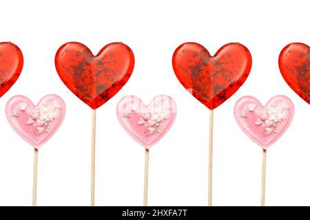 Karte mit wiederholtem roten herzförmigen Lollipop mit Kräutern und rosa Stern Lollipop innen auf einem Stock isoliert auf weiß. Geschenk zum Valentinstag. Quadratisches f Stockfoto