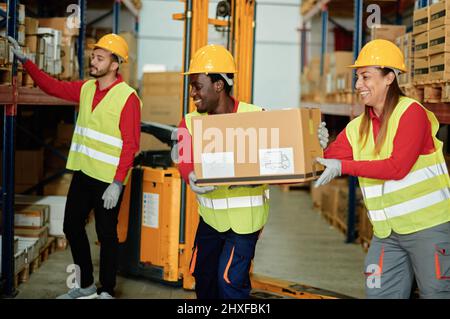 Verschiedene Mitarbeiter mit Kartons im Lager Stockfoto