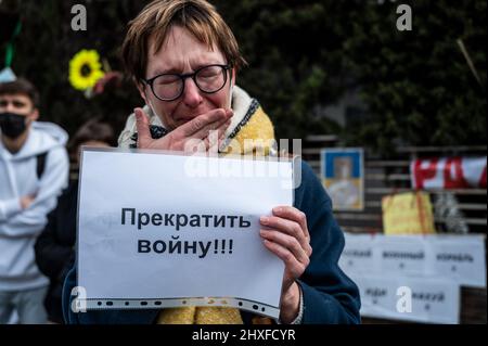 Madrid, Spanien. 12. März 2022. Während eines Protestes gegen den Krieg wird eine Frau weinen sehen, die ein Plakat hält. In Madrid lebende Ukrainer und Russen versammelten sich, um vor der russischen Botschaft gegen die russische Invasion in der Ukraine zu protestieren und das Ende des Krieges zu fordern. Quelle: Marcos del Mazo/Alamy Live News Stockfoto