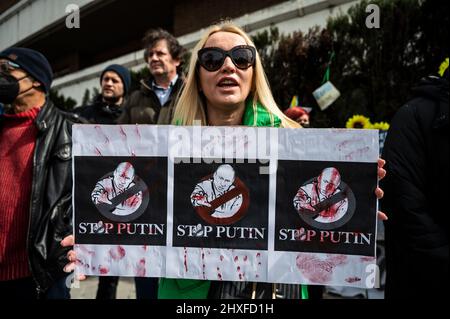 Madrid, Spanien. 12. März 2022. Während eines Protestes gegen den Krieg wird eine Frau mit einem Plakat gegen den russischen Präsidenten Wladimir Putin gesehen. In Madrid lebende Ukrainer und Russen versammelten sich, um vor der russischen Botschaft gegen die russische Invasion in der Ukraine zu protestieren und das Ende des Krieges zu fordern. Quelle: Marcos del Mazo/Alamy Live News Stockfoto