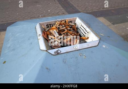 Zigaretten in einem öffentlichen Aschenbecher ausstacheln Stockfoto