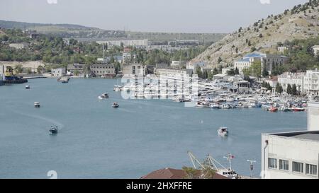 Luftaufnahme des Luxushafens an einem Sommertag mit vielen Yachten. Aktion. Sommer kleine Stadt mit wachsenden Bäumen und Bergen. Stockfoto