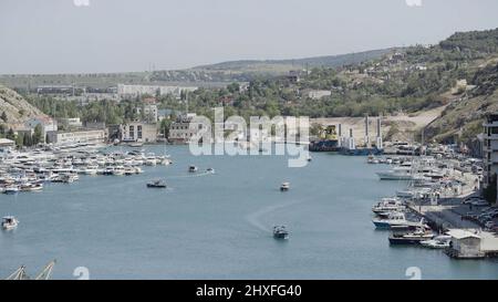 Luftaufnahme des Luxushafens an einem Sommertag mit vielen Yachten. Aktion. Sommer kleine Stadt mit wachsenden Bäumen und Bergen. Stockfoto