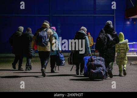 Flüchtlinge sahen, wie sie ihr Gepäck trugen. Ein ehemaliges Einkaufszentrum in Przemysl - von Freiwilligen in eines der größten Flüchtlingshilfezentren der Region verwandelt. Seit Beginn der russischen Invasion in der Ukraine sind über 1,4 Millionen Menschen nach Polen geflohen, um dem Krieg zu entkommen. Ukrainische Flüchtlinge werden mit komplexer Unterstützung sowohl von Wohltätigkeitsorganisationen als auch von einfachen Polen begrüßt, aber viele humanitäre Experten weisen darauf hin, dass bei einem so großen Zustrom von Menschen und nicht ausreichender Unterstützung durch die polnische Regierung innerhalb weniger Wochen eine Krise eintreten könnte. Stockfoto