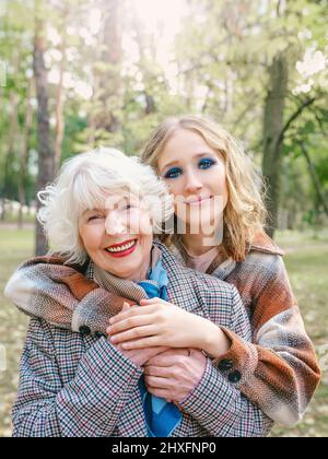 Ältere Frau mit einer jungen Tochter, die im Frühjahr im Freien läuft. Familie, Generation, Pflege, Liebe, Impfkonzept Stockfoto