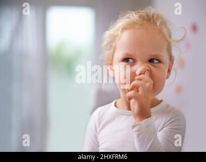 Graben nach Gold. Ein kleines Mädchen, das sich die Nase pflückt. Stockfoto