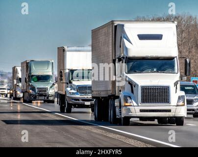 Horizontale Aufnahme eines Konvois aus achtzehn Radschießern auf einer Autobahn. Stockfoto