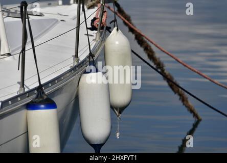 Traditionelles griechisches Segelboot mit Steuerbord mit robuster blauer und weißer Ballonfender und Festmacherseilen. . Stockfoto