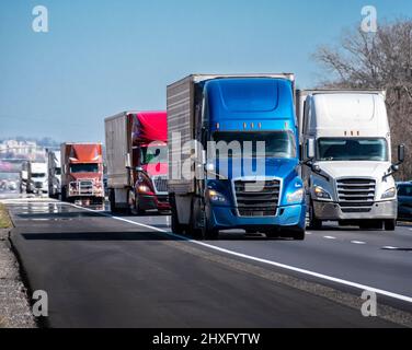 Horizontale Aufnahme eines langen LKW-Konvois auf einer Autobahn. Stockfoto