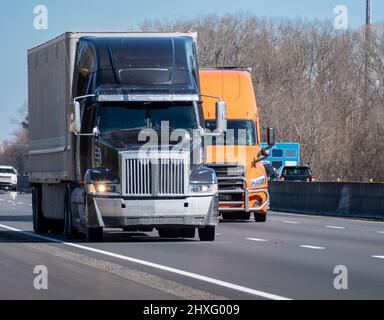 Horizontale Aufnahme von zwei schweren Lastwagen auf einer Autobahn. Stockfoto