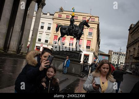 Glasgow, Großbritannien, 12.. März 2022. Die Statue des Herzogs von Wellington in der Queen Street trägt einen blau-gelben Polizeikegelhut mit ukrainischer Flagge, wie von Pauline McWhirter gehäkelt, zur Unterstützung der Ukraine in ihrem aktuellen Krieg mit Präsident PutinÕs Russia, in Glasgow, Schottland, 12. März 2022. Foto: Jeremy Sutton-Hibbert/Alamy Live News. Stockfoto