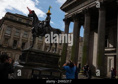 Glasgow, Großbritannien, 12.. März 2022. Die Statue des Herzogs von Wellington in der Queen Street trägt einen blau-gelben Polizeikegelhut mit ukrainischer Flagge, wie von Pauline McWhirter gehäkelt, zur Unterstützung der Ukraine in ihrem aktuellen Krieg mit Präsident PutinÕs Russia, in Glasgow, Schottland, 12. März 2022. Foto: Jeremy Sutton-Hibbert/Alamy Live News. Stockfoto